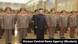 North Korean leader Kim Jong Un, center, pays his respects to his grandfather and North Korea founder, Kim Il Sung, and his father, Kim Jong Il, at Kumsusan Palace of the Sun, Jan. 1, 2015.