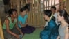 ဒေါ်အောင်ဆန်းစုကြည်နဲ့ ကမ္ဘာကျော်မင်းသမီး အင်ဂျလီနာဂျိုလီတို့ လှိုင်သာယာ ကျူးကျော်ရပ်ကွက်အတွင်းက တဲတလုံးကို သွားရောက်လည်ပတ်ပြီး သိလိုတာတွေကို မေးမြန်းခဲ့စဉ်။ (သြဂုတ် ၁၊ ၂၀၁၅)