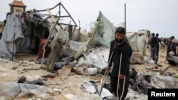Orang-orang Palestina memeriksa puing-puing tenda yang hancur akibat serangan udara Israel di sebuah kamp pengungsi di Rafah, selatan Jalur Gaza, 28 Mei 2024. (Foto: Hatem Khaled/Reuters)