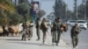 Opposition fighters walk along a street in Aleppo, Syria, after the government army said dozens of its soldiers were killed in a major attack by rebels who swept into the city on Nov. 30, 2024.