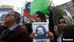 Human rights activists hold a picture of Salman Haider, who is missing, during a protest to condemn the disappearances of social activists in Karachi, Pakistan, Jan. 19, 2017.