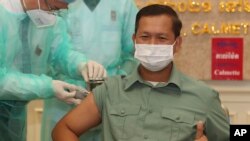 Cambodia's Lt. Gen. Hun Manet, a son of Prime Minister Hun Sen, thumbs up as he receives a shot of the COVID-19 vaccine at Calmette hospital in Phnom Penh, Cambodia, Wednesday, Feb. 10, 2021. (AP Photo/Heng Sinith)