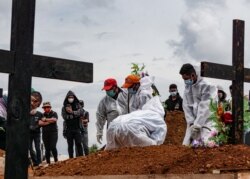 Penggali kubur mengenakan alat pelindung diri (APD) di area pemakaman yang disediakan pemerintah untuk korban COVID-19, seiring lonjakan kasus di Jayapura, Papua, 20 Juli 2021. (Foto: Antara/Indrayadi TH via REUTERS)