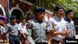 រូបឯកសារ៖ អ្នក​កាសែត​ Reuters លោក Wa Lone (កណ្ដាល ជួរមុខ) និង​លោក Kyaw Soe Oo (កណ្ដាល ជួរក្រោយ) ត្រូវ​បាន​នាំ​មក​សវនាការ​កាល​ពី​ថ្ងៃទី​២០​ មេសា ២០១៨ នៅ​តុលាការ​ក្នុង​ទីក្រុង​រ៉ង់ហ្គូន ប្រទេស​មីយ៉ាន់ម៉ា។ (រូបថត AP)