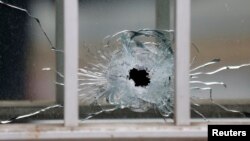 Bekas tembakan tampak di sebuah jendela pada kantor tabloid mingguan Charlie Hebdo di Paris (7/1).