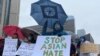 FILE - People hold placards as they gather to protest anti-Asian hate crimes, racism and vandalism, outside City Hall in Toronto, Ontario, Canada, March 28, 2021.