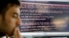 Razvan Muresan, a Bitdefender public relations specialist, is backdropped by a screenshot of the message displayed on computers affected by the latest cyberattack, in Bucharest, Romania, June 28, 2017. A new, highly virulent strain of malicious ransom so