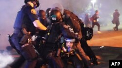 Empat petugas polisi Portland menangkap seorang pengunjuk rasa di dekat Mississippi Avenue pada 14 Agustus 2020 di Portland, Oregon. (Foto: AFP)