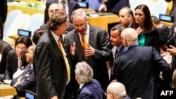 Duta Besar Belanda untuk PBB Karel van Oosterom (tengah) berbicara dengan Menteri Luar Negeri Italia Paolo Gentiloni (duduk, tengah), disaksikan Menteri Luar Negeri Belanda Bert Koenders (kiri) dan Duta Besar Italia untuk PBB Sebastiano Cardi (kanan) dalam sidang Dewan Keamanan PBB di New York (28/6). (AFP/Kena Betancur)