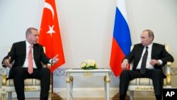 Presiden Turki Recep Tayyip Erdogan (kiri) berbicara dengan Presiden Rusia Vladimir Putin dalam pertemuan di istana Konstantin di luar kota St.Petersburg, Rusia (9/8). (AP/Alexander Zemlianichenko)