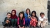 Anak-anak duduk di depan sebuah rumah di desa Deh Qubad di distrik Maiwand, Provinsi Kandahar, Afghanistan, 27 September 2020. (Foto: AFP)