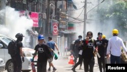Polisi menembakkan gas air mata pada para demonstran saat mereka melarikan diri \, di Yangon, Myanmar, 8 Maret 2021. (Foto: Reuters)