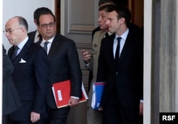 Dari kiri, Menteri Dalam Negeri Perancis Bernard Cazeneuve dan Presiden Francois Hollande dan pejabat pemerintah lainnya keluar dari Istana Elysee setelah rapat dengan Dewan Pertahanan setelah serangan pada hari Jumat (13/11) di Paris, Perancis, 14 November 2015.