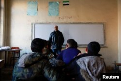 Para siswa duduk di ruang kelas sebuah sekolah pada dini hari setelah pengumuman pembukaan kembali sekolah oleh pihak berwenang, di Damaskus, 15 Desember 2024. (Foto: Reuters)