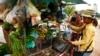 A vendor, right, holds a plastic bag containing salty fish at her mobile market in Kporb A-Tiev village, Kandal province, east of Phnom Penh, Cambodia. (AP Photo/Heng Sinith)