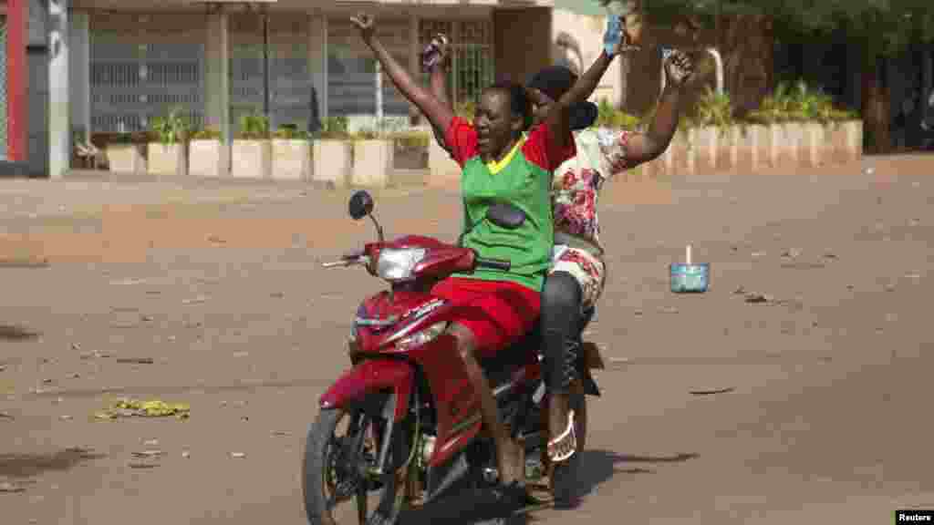 People gesture as they celebrate the departure of Burkina Faso's President Blaise Compaore in Ouagadougou, capital of Burkina Faso, Oct. 31, 2014.