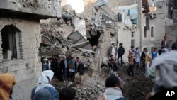 FILE - People gather at the site of a Saudi-led airstrike near Yemen's Defense Ministry complex in Sanaa, Yemen, Saturday, Nov. 11, 2017. 