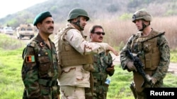 FILE - Afghan national army officers discuss lessons learned alongside Marines and Navy personnel while participating in combat scenario training exercises at U.S. Marine Corps Base Camp Pendleton in California, Jan. 14, 2010. 