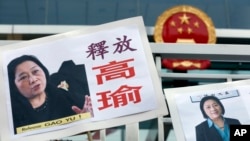 FILE - Pictures of jailed veteran Chinese journalist Gao Yu are displayed by protesters outside Chinese central government's liaison office in Hong Kong.