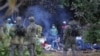 Petugas patroli perbatasan Polandia menjaga sekelompok migran yang berusaha melintasi perbatasan antara Belarus dan Polandia di dekat desa Usnarz Gorny, Polandia, 18 Agustus 2021. (Foto: Grzegorz Dabrowski/Agencja Gazeta via REUTERS)