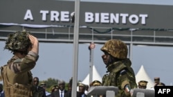 Seorang tentara Prancis (kiri) memberi salam hormat kepada tentara Pantai Gading saat pasukan Prancis bersiap meninggalkan Kamp Thomas d'Aquin Ouattara, yang sempat menjadi Pangkalan Batalion Infanteri Marinir Prancis ke-43, di Abidjan, pada 20 Februari 2025. (Foto: AFP)