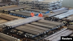 Pekerja di pabrik baja memeriksa produk baja di sebuah pabrik di Dalian, Provinsi Liaoning, China, 30 Maret 2016. (Foto: dok).