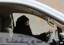 FILE - A woman drives a car on a highway in Riyadh, Saudi Arabia, as part of a campaign to defy Saudi Arabia's ban on women driving, March 29, 2014.