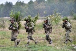 FILE - Soldiers take part in exercises at the Yavoriv military training ground, near Lviv, western Ukraine, Sept 24, 2021, as part of joint drills between the U.S., other NATO countries and Ukraine.