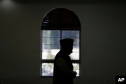 FILE - An imam prays at a mosque in Chino, California, Nov. 18, 2016. Targeting clerics opposed to the Islamic State in a new propaganda campaign, the jihadist group is thought to have launched an effort aimed at deligitimizing them, especially in the eye