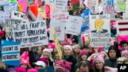 Para perempuan peserta pawai mengenakan topi berwarna merah muda (pink) berkumpul sejak dini hari untuk menggelar protes pada hari pertama kepresidenan Donald Trump, Sabtu, 21 Januari, 2017 di Washington. Protes lain juga digelar secara serentak di beberapa kota besar lain di AS. (AP Photo / Jose Luis Magana)