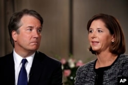 FILE - Brett Kavanaugh, left, looks at his wife Ashley Estes Kavanaugh as they answer questions during a FOX News interview, Sept. 24, 2018, in Washington, about allegations of sexual misconduct against the Supreme Court nominee.