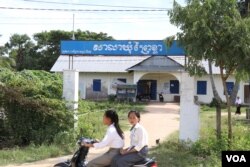 Students drive past the Prey Khla commune office in Takeo province, Nov. 27, 2017.