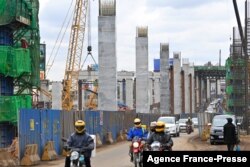 FILE - Motorists drive on Mombasa road, next to the ongoing construction site of the Nairobi Expressway, undertaken by the Chinese contractor China Road and Bridge Corporation (CRBC), in Nairobi, Kenya, July 12, 2021.