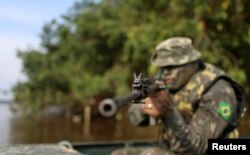 A Brazilian Army soldier patrols the border with Colombia during a training to show efforts to step up security along borders, in Vila Bittencourt, Amazon State, Brazil, Jan. 18, 2017.