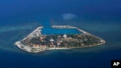 FILE - The Vietnamese-claimed Southwest Cay island in the Spratly island group is seen from a Philippine Air Force C-130 transport plane during the visit to the Philippine-claimed Thitu Island by Defense Secretary Delfin Lorenzana, Armed Forces Chief Gen.