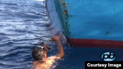 A Vietnamese fisherman repairs his vessel after it was rammed by a Chinese patrol ship that it protecting the waters around a disputed oil rig in the South China Sea, May 18, 2014. (PhoBolsaTV.com)