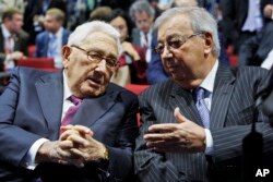 FILE - Former Russian premier minister Yevgeny Primakov, right, and former U.S. Secretary of State Henry Kissinger speak as they take part in economic forum in St.Petersburg, Russia, June 21, 2012.