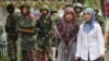 Dua perempuan etnis Uighur melewati polisi paramiliter China yang berjaga di luar Grand Bazaar di distrik Uighur di kota Urumqi di wilayah Xinjiang China pada 14 Juli 2009. (Foto: AFP/Peter Parks)