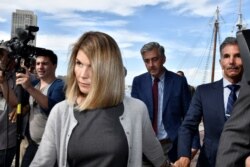 FILE - Actress Lori Loughlin and her husband, fashion designer Mossimo Giannulli, leave the federal courthouse after a hearing on charges in a nationwide college admissions cheating scheme in Boston, Aug. 27, 2019.