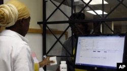 FILE - A patient receives medication from a pharmacist at the Helen Joseph hospital in Johannesburg, South Africa, Nov. 15, 2012.