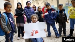 Tesnim Fayd (8 tahun) anak perempuan pengungsi Suriah menunjukkan hasil lukisannya "seorang Ibu yang menangis karena anak perempuannya terluka akibat konflik", di kamp pengungsi Hatay, Turki (foto: dok). 
