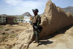 FILE - An Afghan commando stands guard at the site of a suicide bomb attack on the outskirts of Kabul, April 29, 2020.