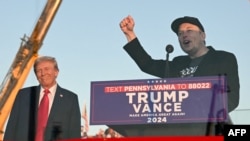 Elon Musk (dama) yayin da yake magana a kan dandamali a wani gangamin baya-bayan nan a Pennsylvania.