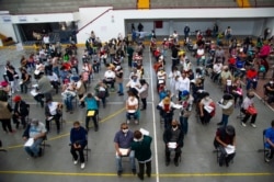 FILE - People wait to receive the first dose of China's Sinovac Biotech CoronaVac vaccine against COVID-19, in Ecatepec, Mexico state, Feb. 22, 2021.