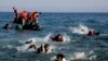FILE - Migrants whose boat stalled at sea while crossing from Turkey to Greece swim to approach the shore of the island of Lesbos, Greece, Sept. 20, 2015. 