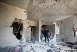 A Palestinian man gestures as he inspects a damaged building following an Israeli air strike, amid a flare-up of Israeli-Palestinian violence, in Gaza City, May 11, 2021.