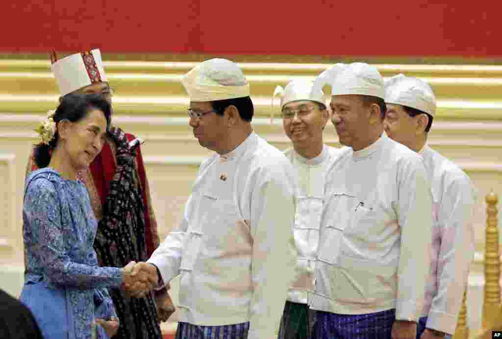 Aung San Suu Kyi, left, greets members of Myanmar&#39;s old cabinet during a presidential handover ceremony in Naypyitaw.