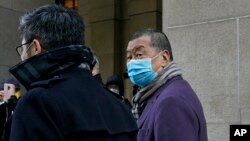 FILE - Hong Kong pro-democracy activist and media tycoon Jimmy Lai, right, leaves the Court of Final Appeal during a break in Hong Kong, Dec. 31, 2020. 