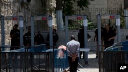 Seorang pria Palestina berjalan melewati alat pendeteksi metal di kompleks Masjid Al Aqsa di kota tua Yerusalem, 19 Juli 2017.