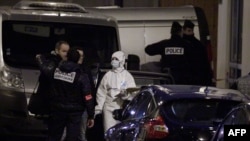 Polisi dan petugas forensik berdiri di luar kantor koran mingguan Charlie Hebdo di Paris (7/1). (AFP/Matthieu Alexandre)